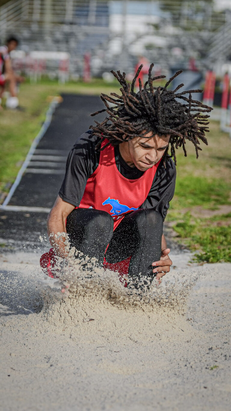 Long jumper lands in the pit with sand flying