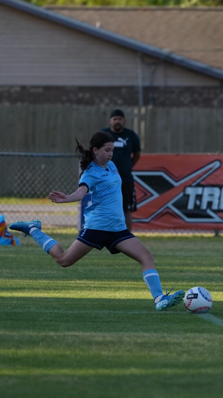 Girls soccer player mid-strike