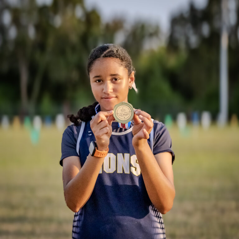 Athlete holds up her medal after the race